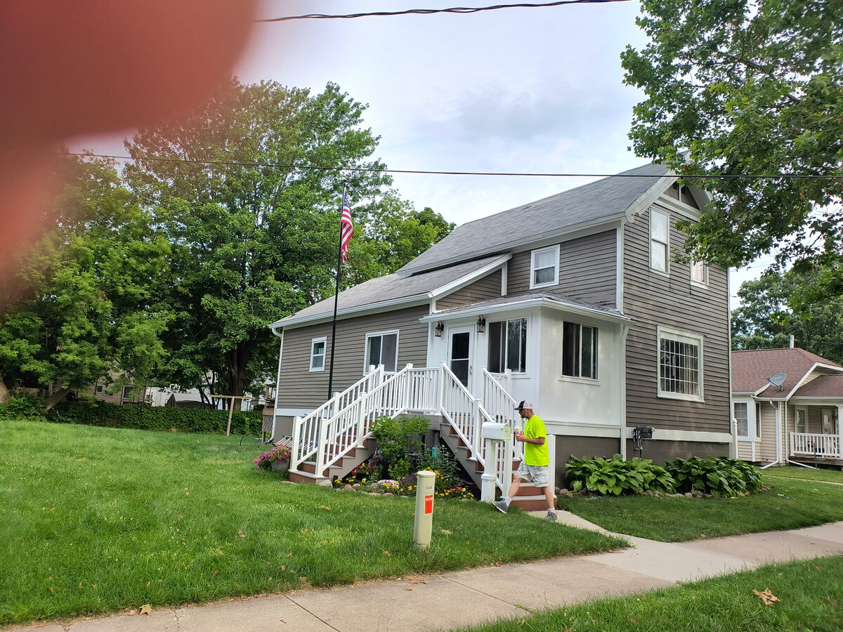 Rick Humpert of Humpert Painting LLC standing on the steps of a freshly painted home in Bay City, MI